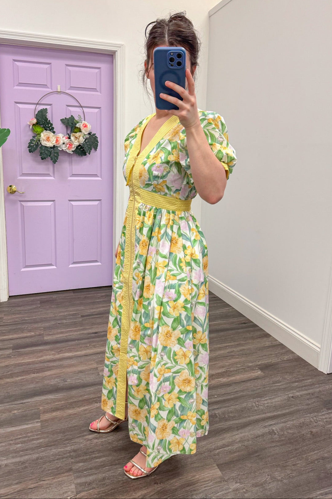 Side view of Yellow and green floral midi dress paired with gold strappy sandals